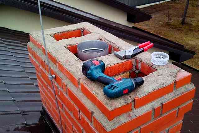Верхний конец нержавеющей гильзы, стоящей в кирпичной шахте Верхний конец нержавеющей гильзы, стоящей в кирпичной шахте